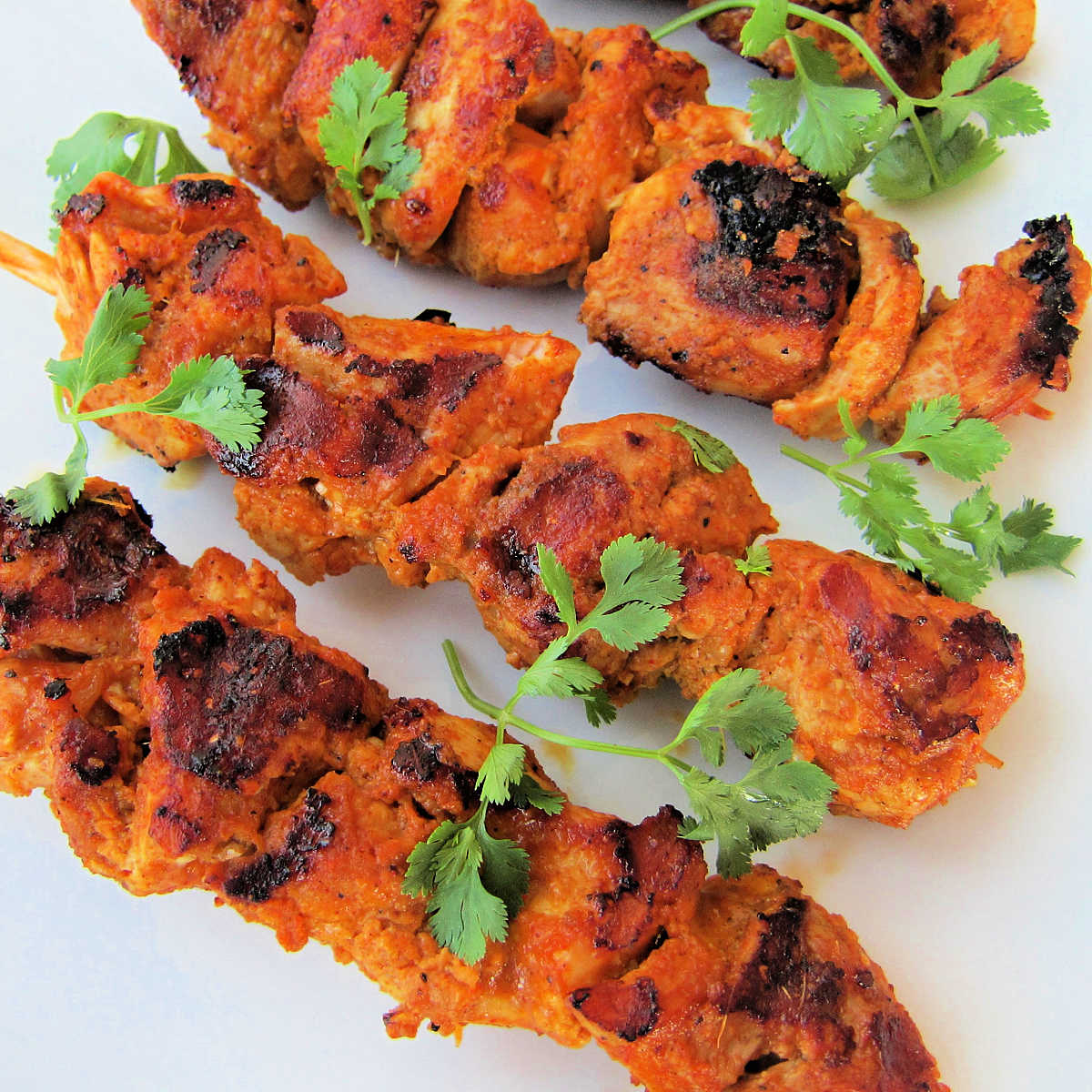 Tandoori chicken kebabs on a white plate