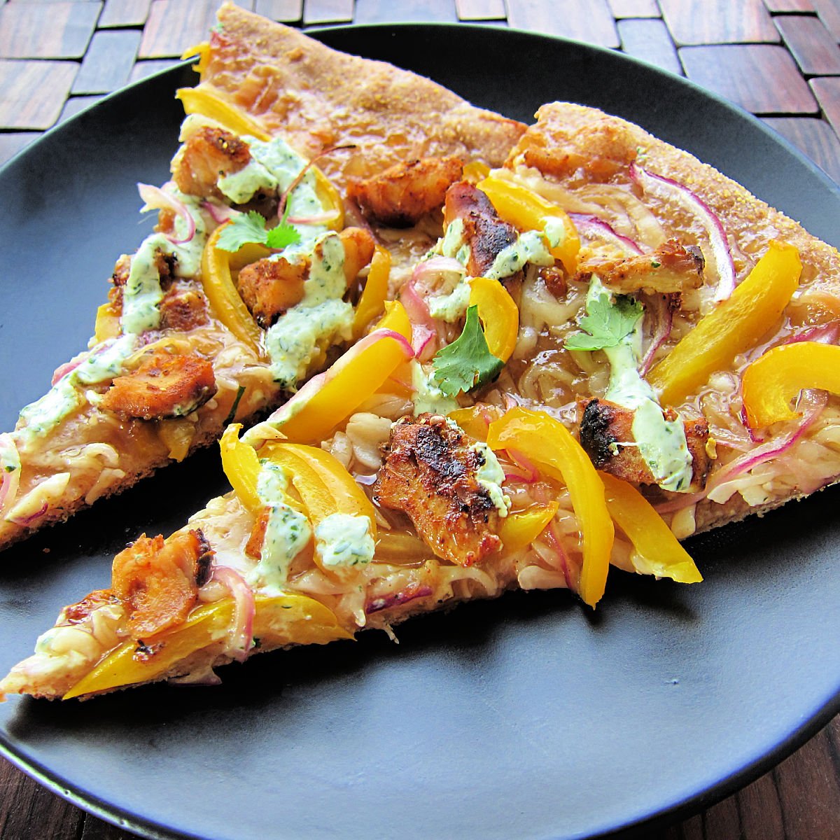 Two slices of Tandoori chicken pizza 