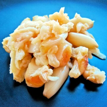 Pile of roasted garlic on a black plate