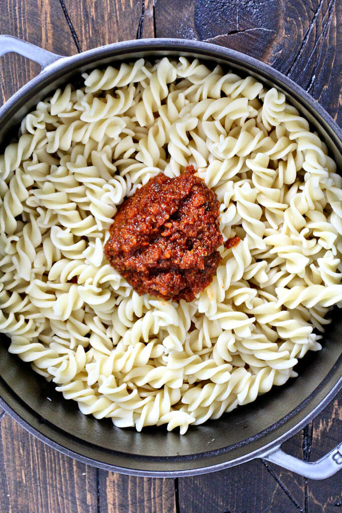pesto rosso added to pasta