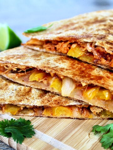 pulled chicken quesadillas stacked on a board