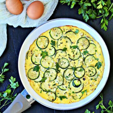 Summer Zucchini and Corn Frittata in white frying pan.