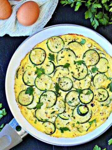 Summer Zucchini and Corn Frittata in white frying pan.