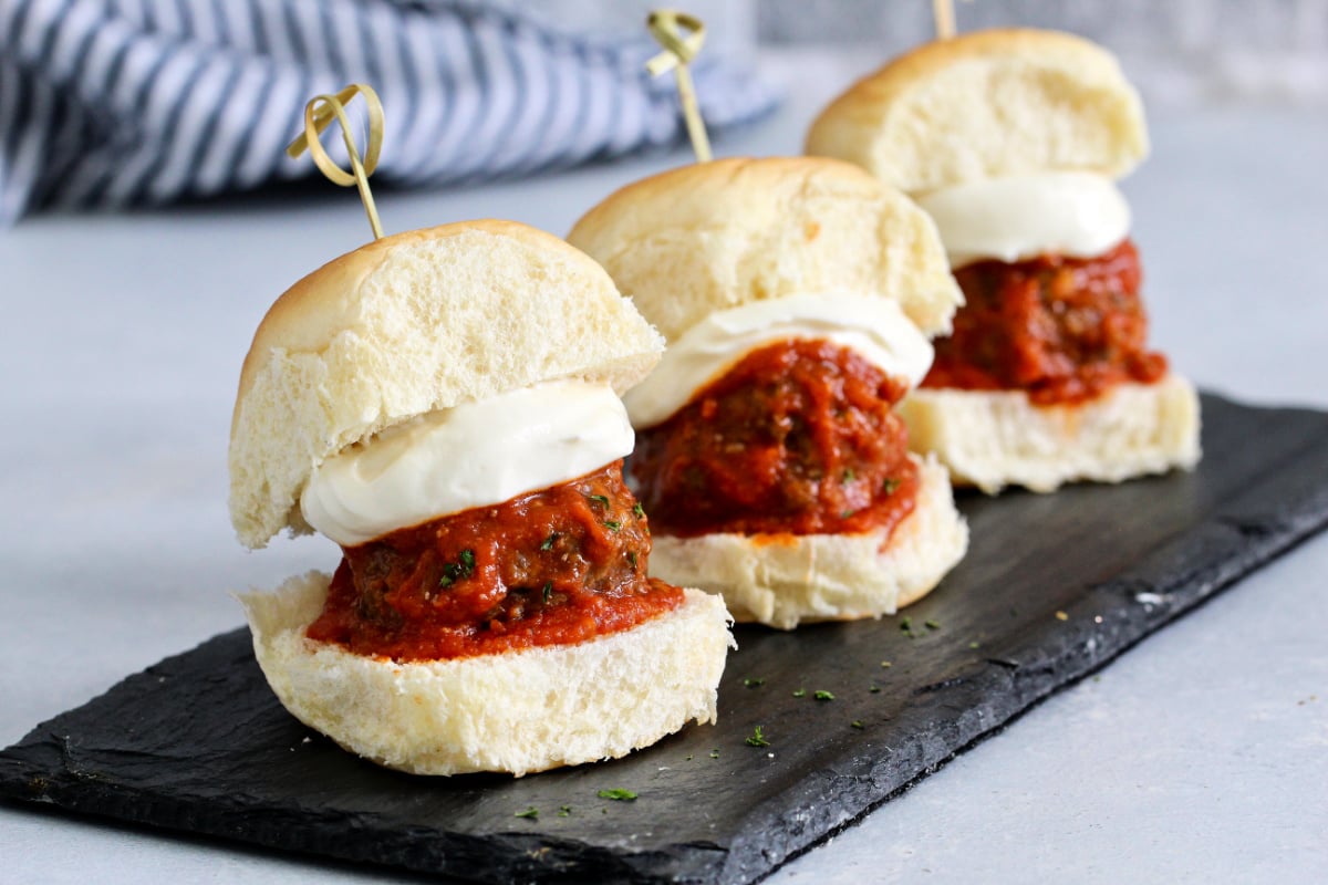 Row of meatball sliders with whipped ricotta