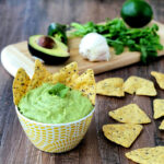 Avocado Yogurt Dip in a bowl surrounded by tortilla chips.
