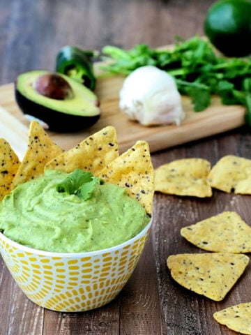 Avocado Yogurt Dip in a bowl surrounded by tortilla chips.