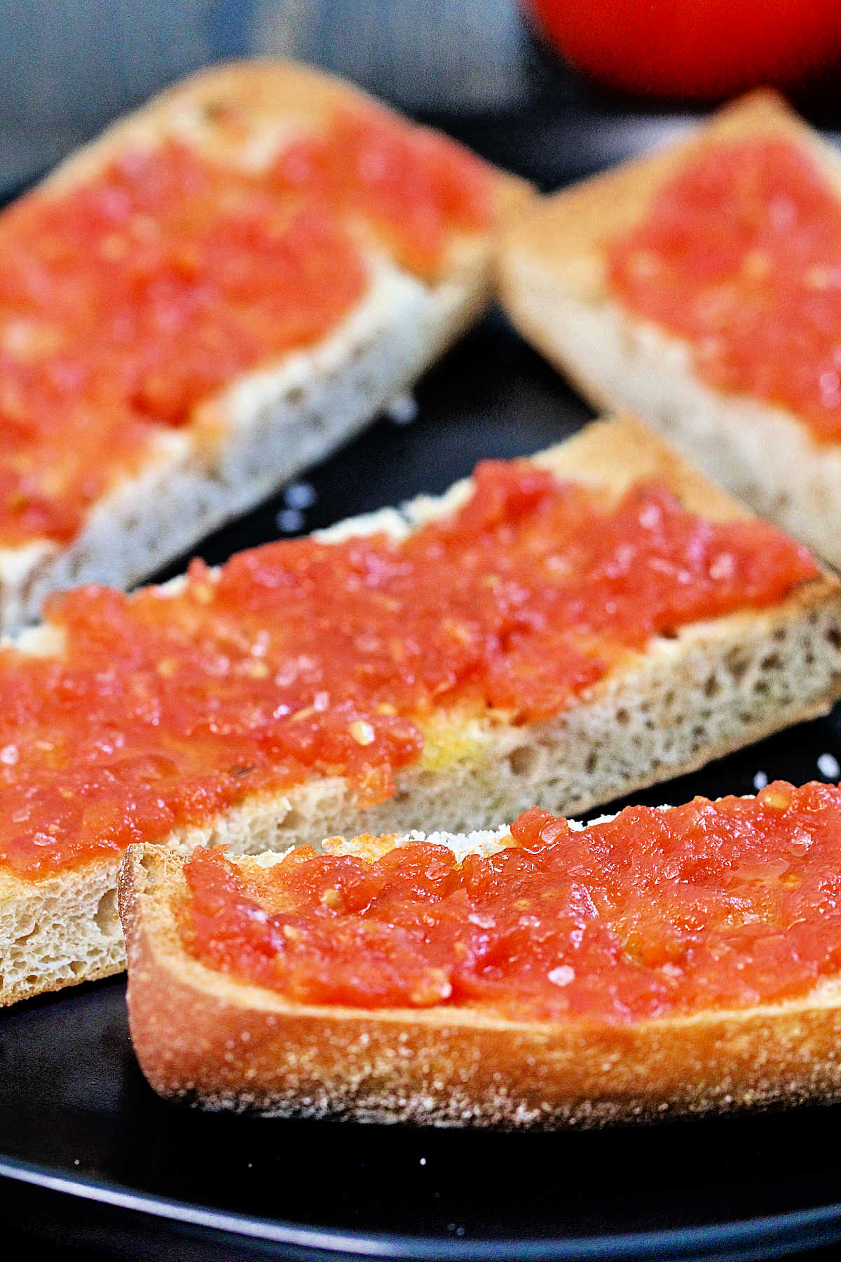 Close up of pan con tomate on a black plate
