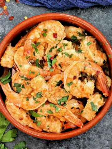 Overhead shot of Spanish garlic shrimp in a brown dish.