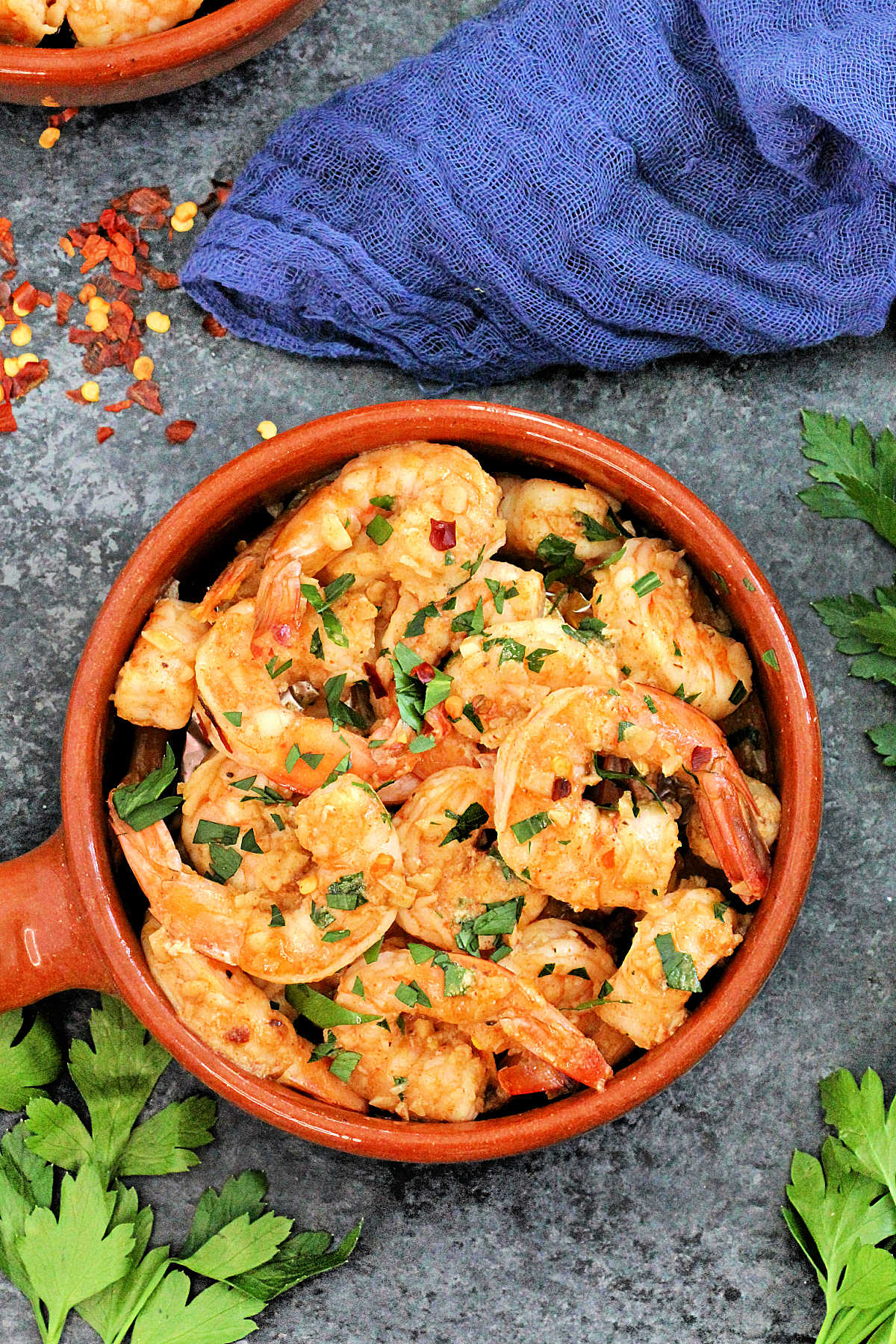 Overhead shot of Spanish garlic shrimp in a brown dish.
