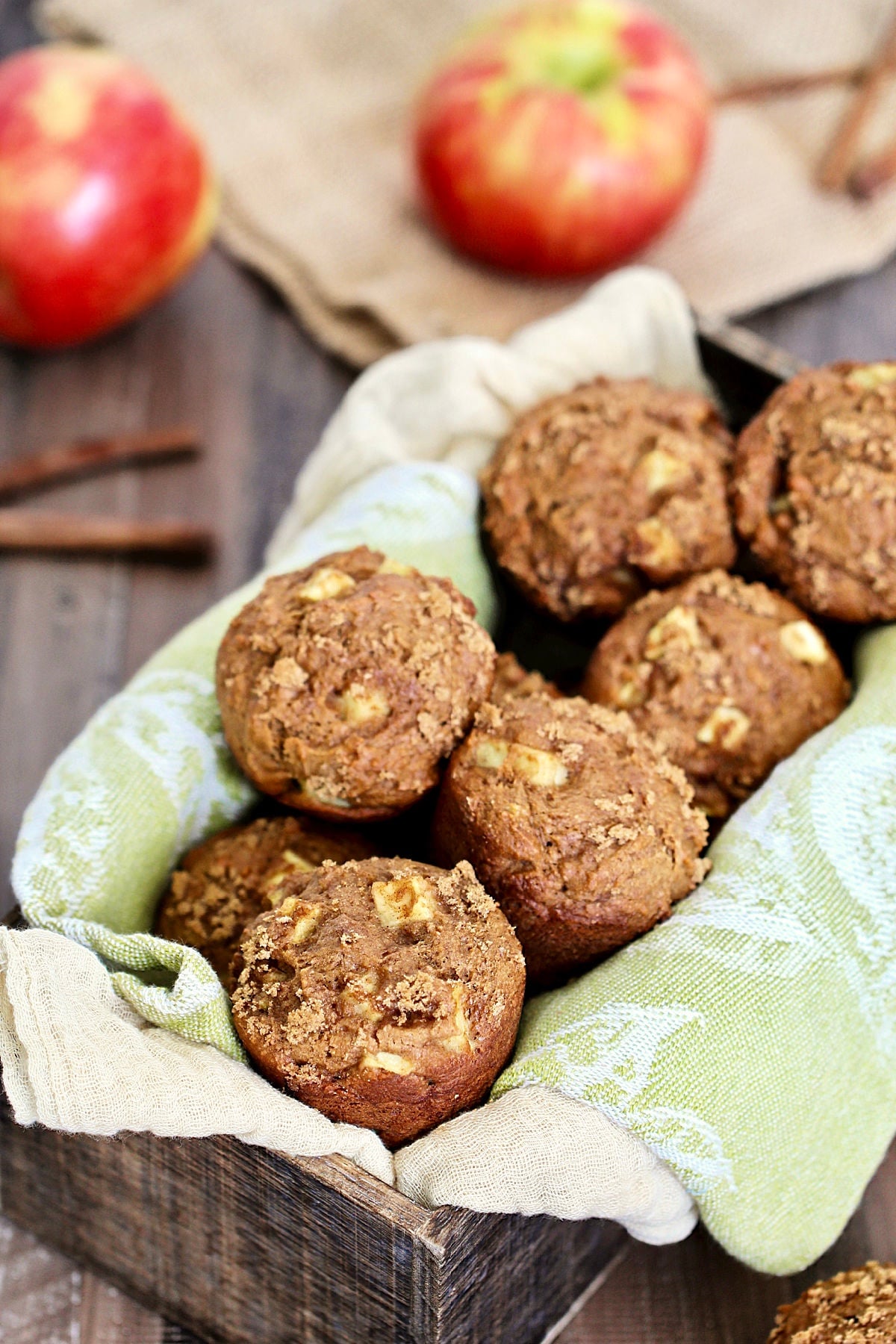 Basket of spiced apple muffins on a green napkin.