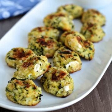 Zucchini tots on a white plate.
