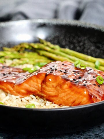 air fryer salmon teriyaki on a bowl with brown rice and asparagus.