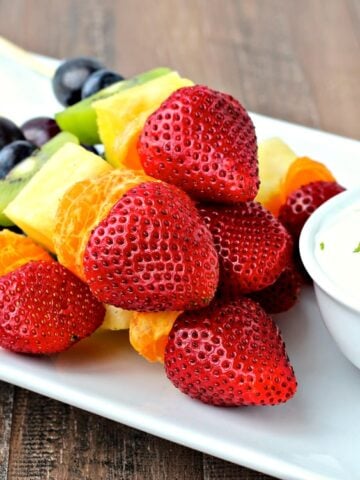 Rainbow Fruit Kabobs on a white platter.