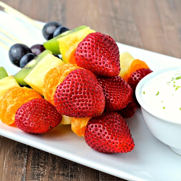 Rainbow Fruit Kabobs on a white platter.