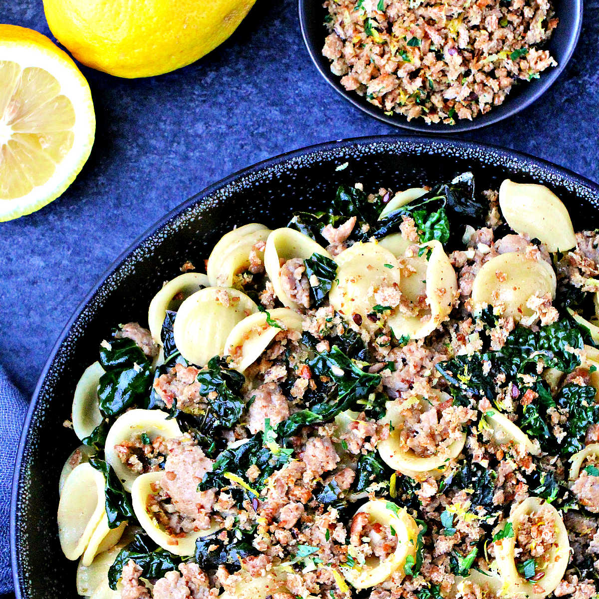 Orecchiette with Kale, Turkey Sausage and Gremolata Breadcrumbs in a black bowl.