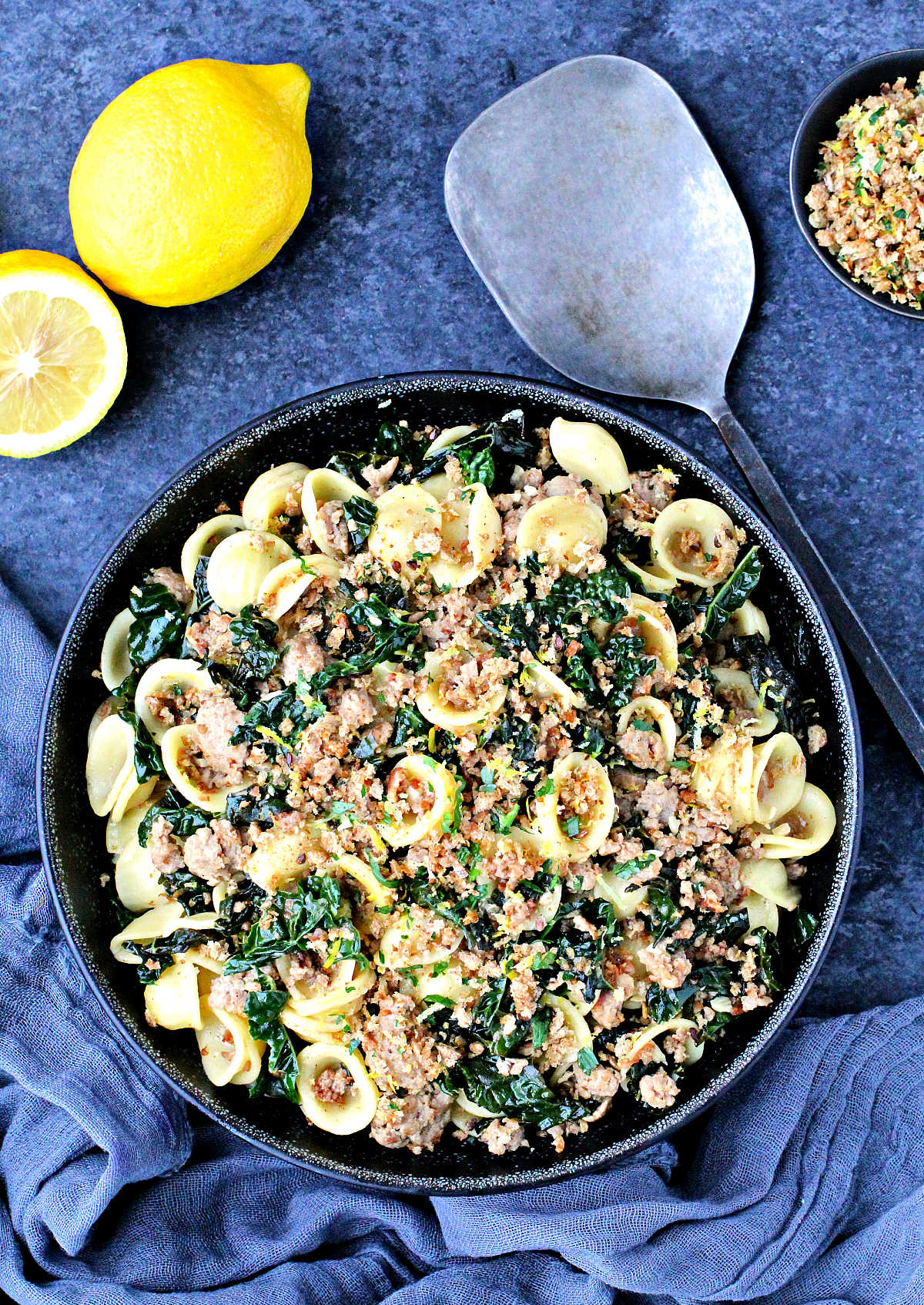 Overhead of Orecchiette with Kale, Turkey Sausage and Gremolata Breadcrumbs in a black bowl.