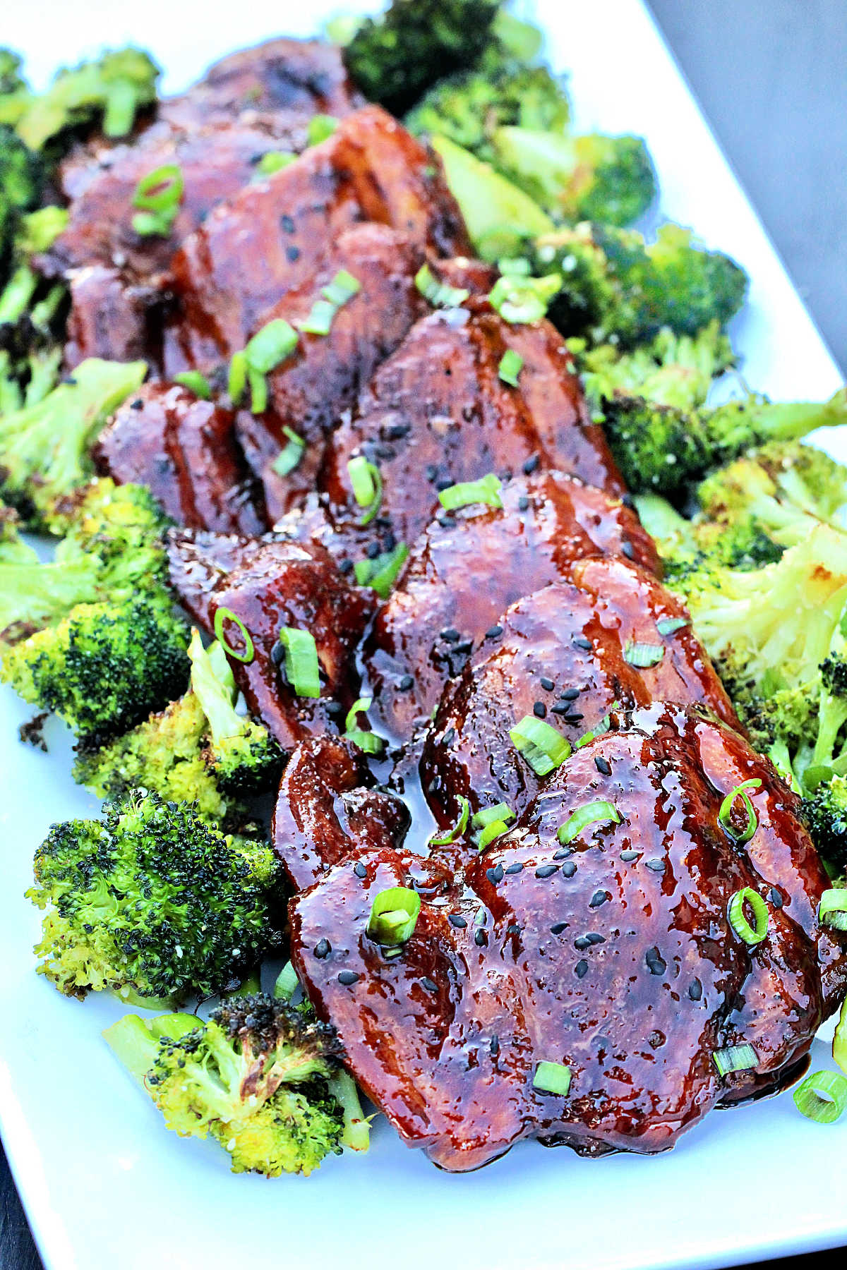 Pieces of chicken teriyaki on a bed of broccoli.