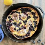 Blueberry lemon dutch baby in a cast iron skillet.