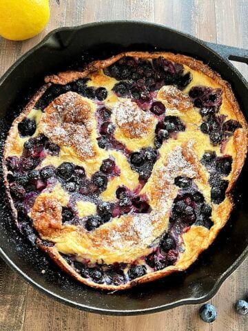 Blueberry lemon dutch baby in a cast iron skillet.