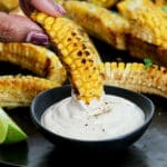 A corn rib being dunked into Southwest dipping sauce