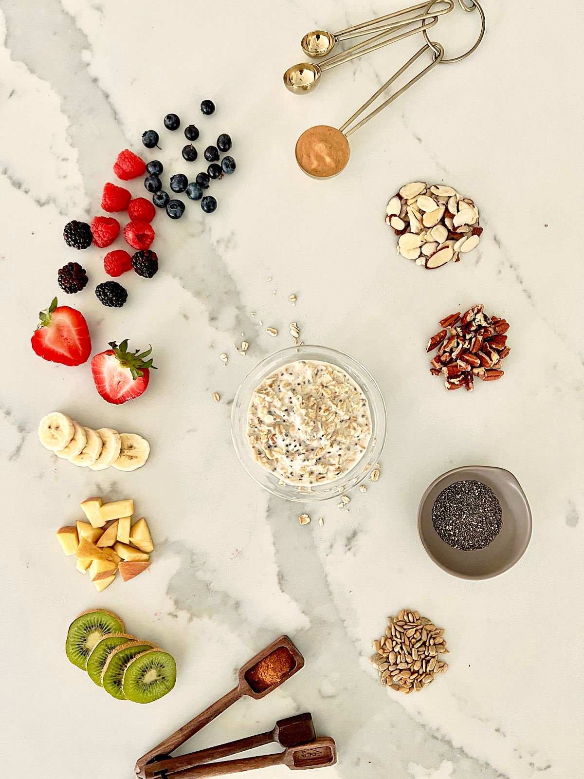 Overhead picture of healthy overnight oats surrounded by various toppings and measuring spoons.