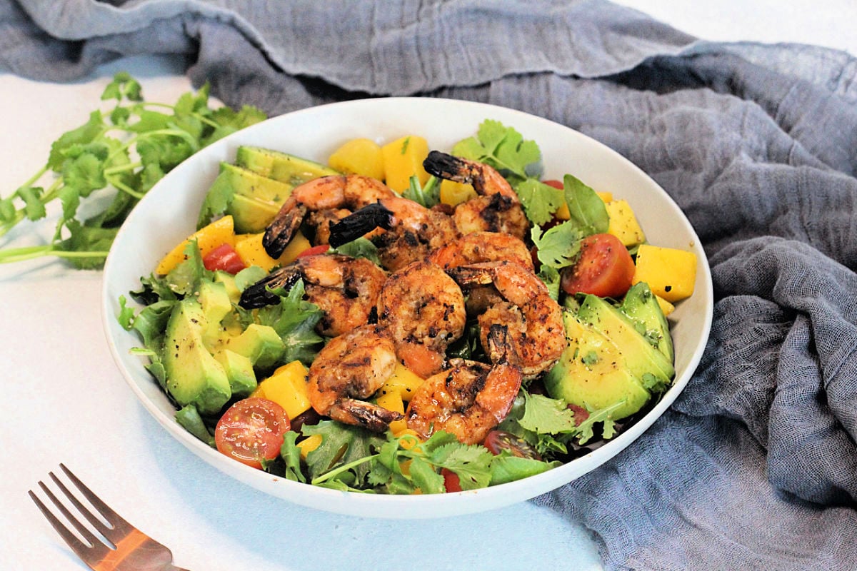 Grilled Shrimp Salad in a white bowl surrounded by a gray napkin