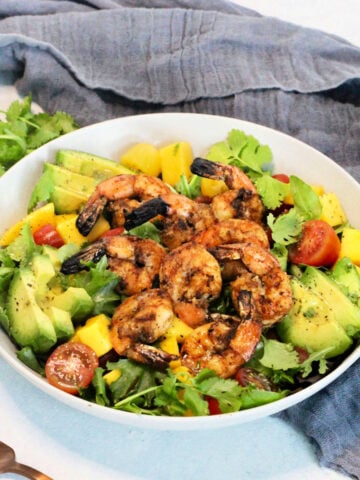 Grilled Shrimp Salad in a white bowl surrounded by a gray napkin
