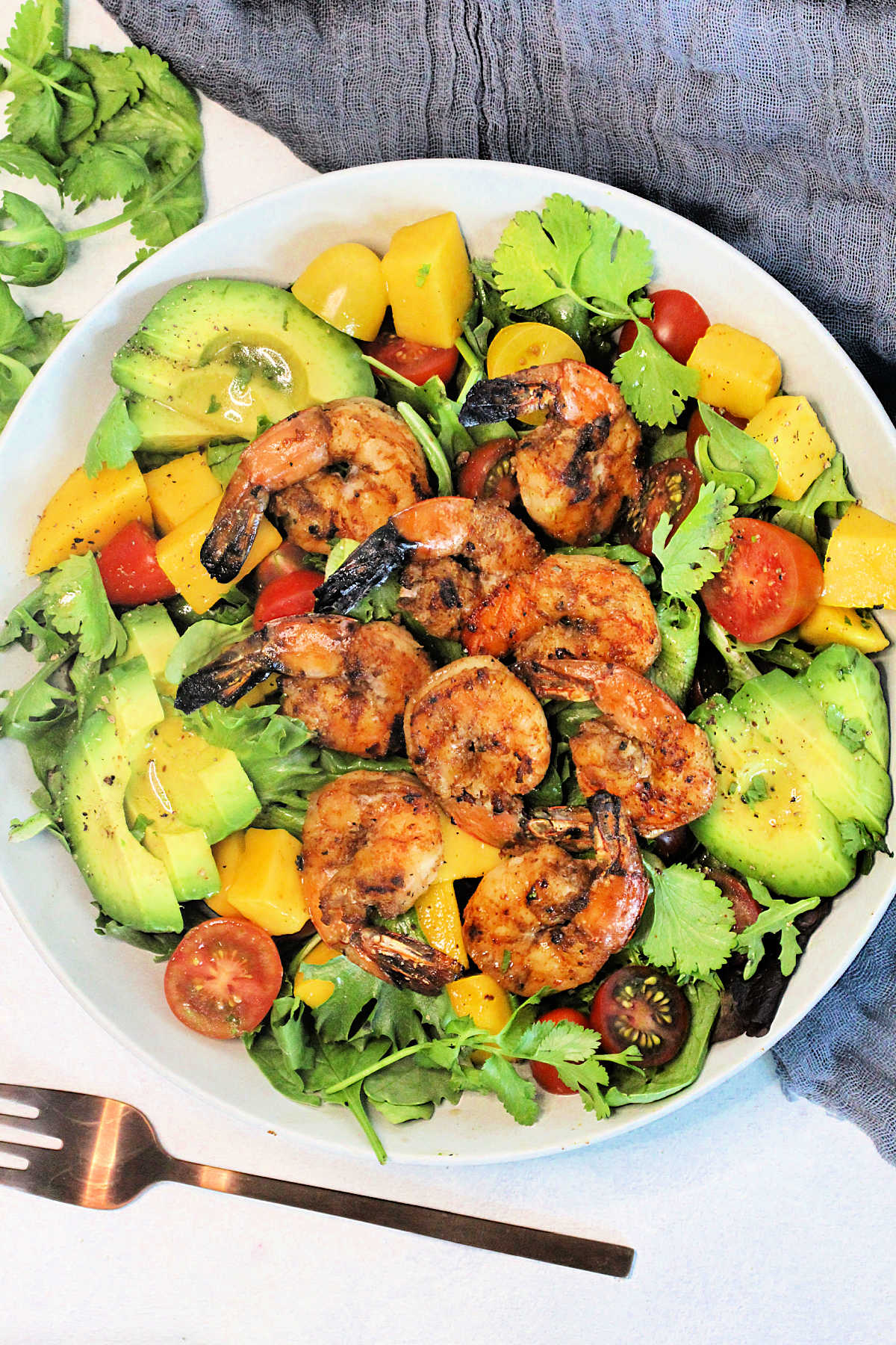 Grilled Shrimp Salad in a white bowl surrounded by a gray napkin