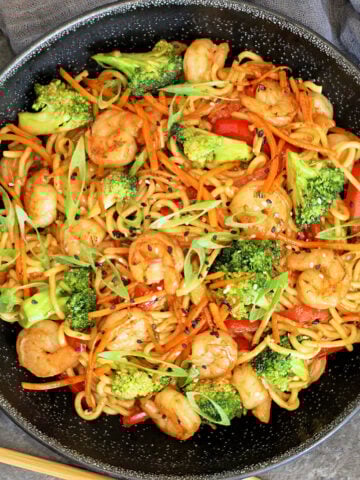 Overhead of Shrimp Stir Fry with Noodles in a black bowl.