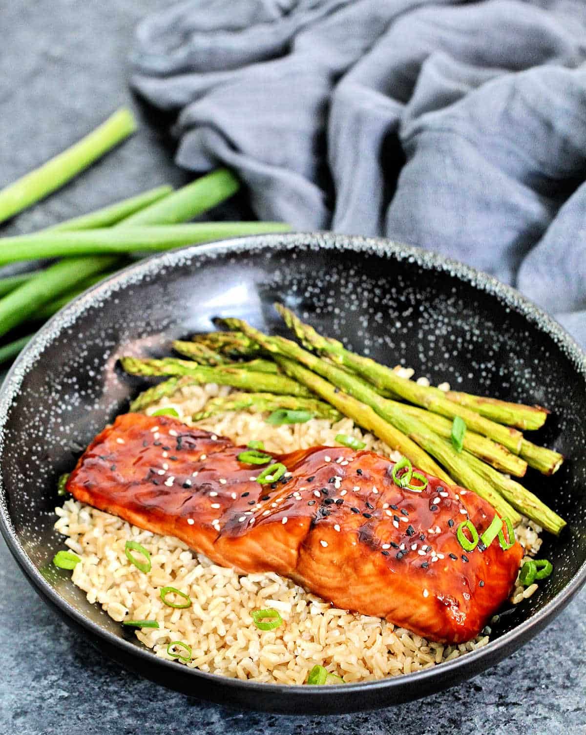 air fryer salmon teriyaki on a bowl with brown rice and asparagus.