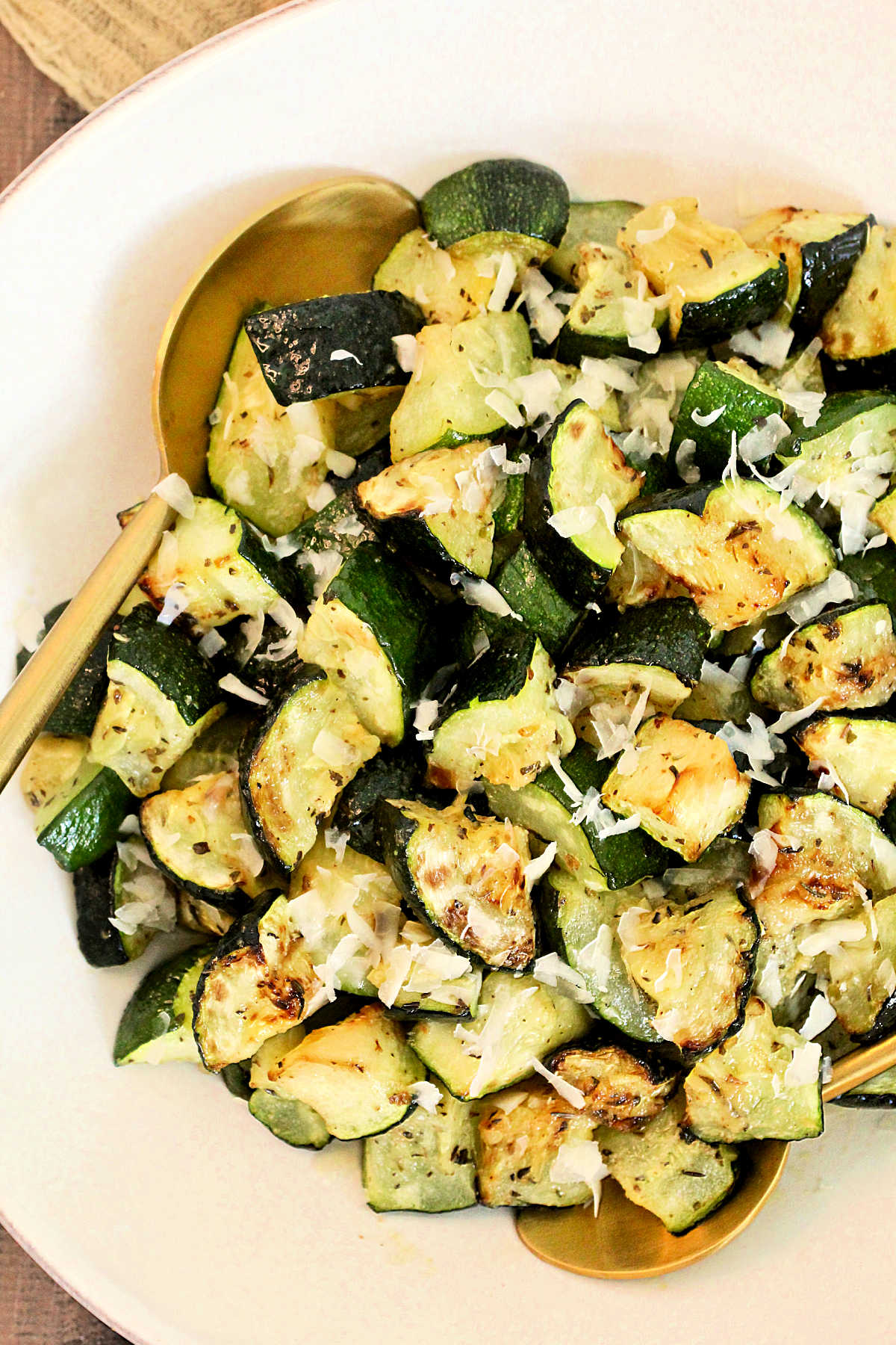 Overhead photo of air fryer zucchini in a white bowl.