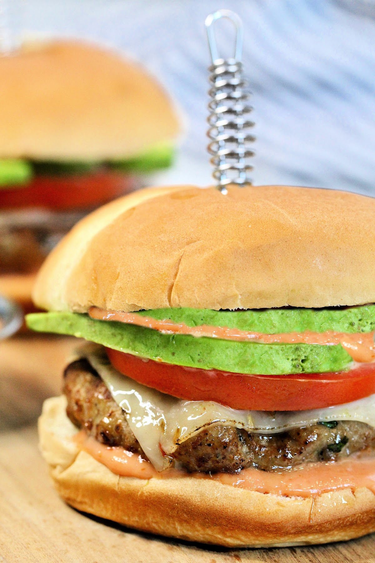 Turkey burger with cheese, tomato and avocado.