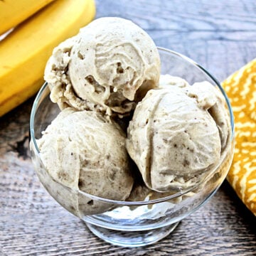 Overhead shot of three scoops of one-ingredient banana ice cream in a glass bowl.