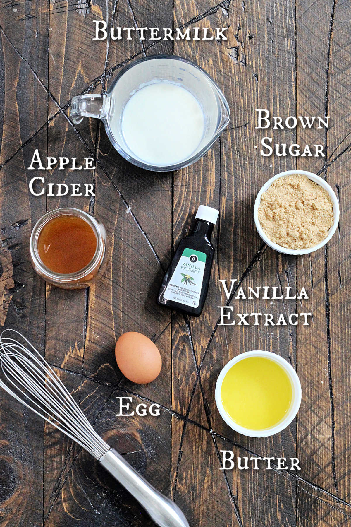 Wet ingredients for baked apple cider donuts on a brown wooden board. 