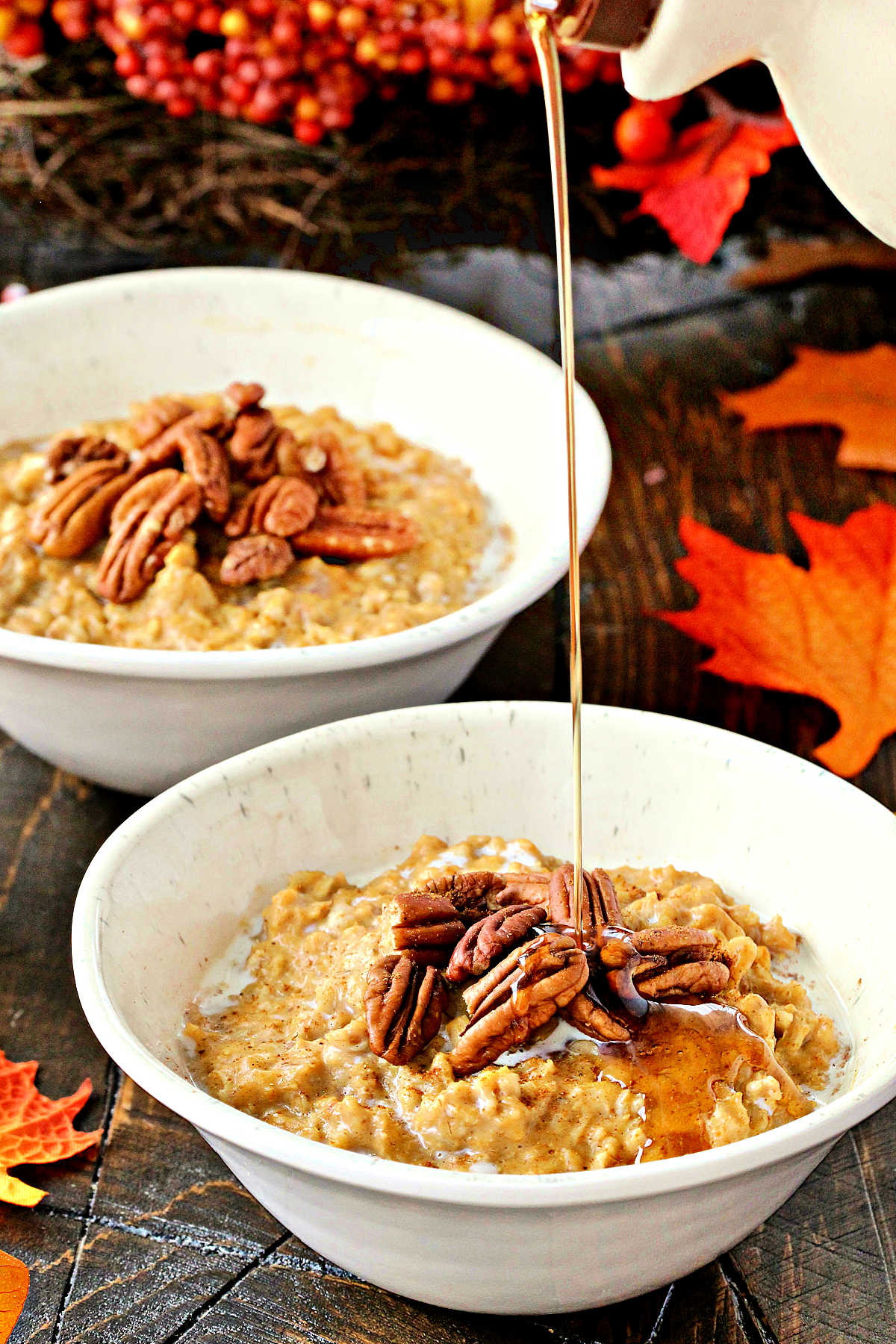 Maple syrup being poured onto a bowl of Pumpkin Spice Oatmeal.