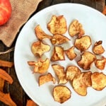 Air fryer apple chips on a white plate.