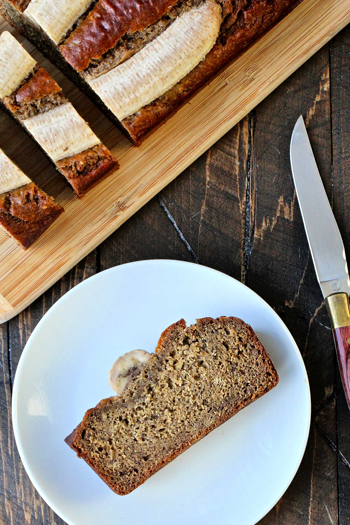 A slice of banana flaxseed bread on a white plate.