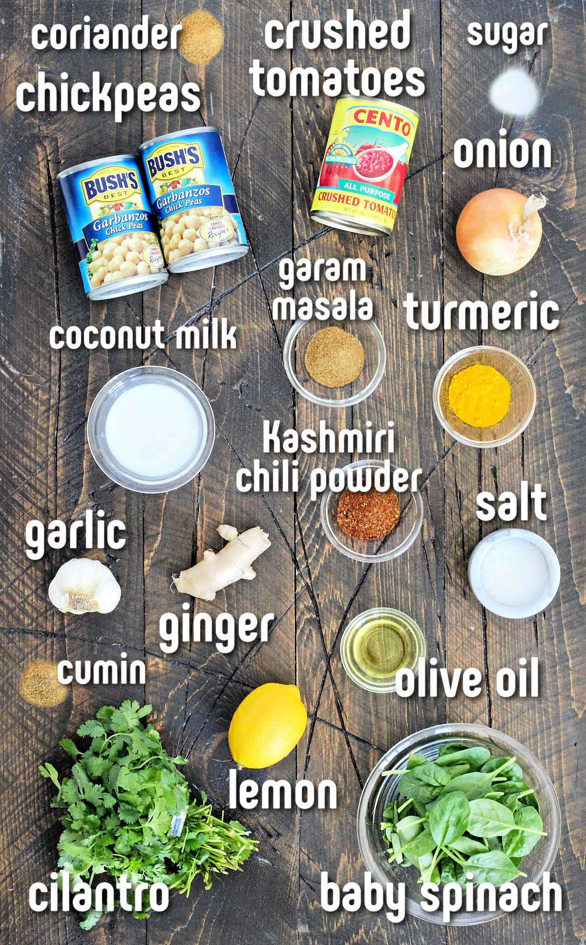 Ingredients for chickpea spinach curry on a brown wooden board.