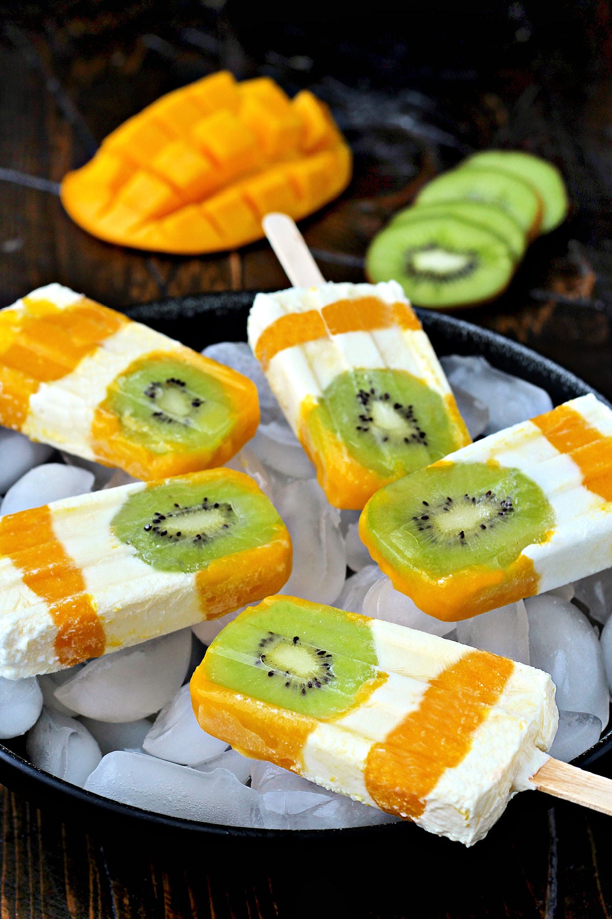 Kiwi Mango Popsicles on bowl of ice.