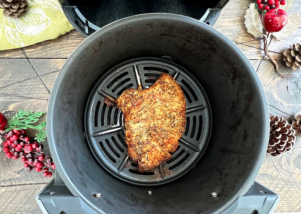 Air fryer turkey tenderloin in air fryer basket. 