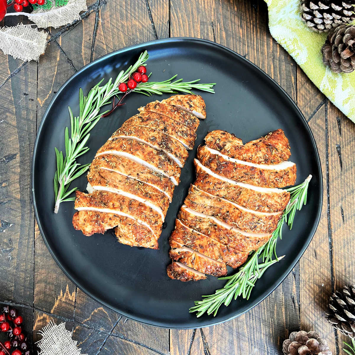 Two turkey tenderloins on a black plate. 
