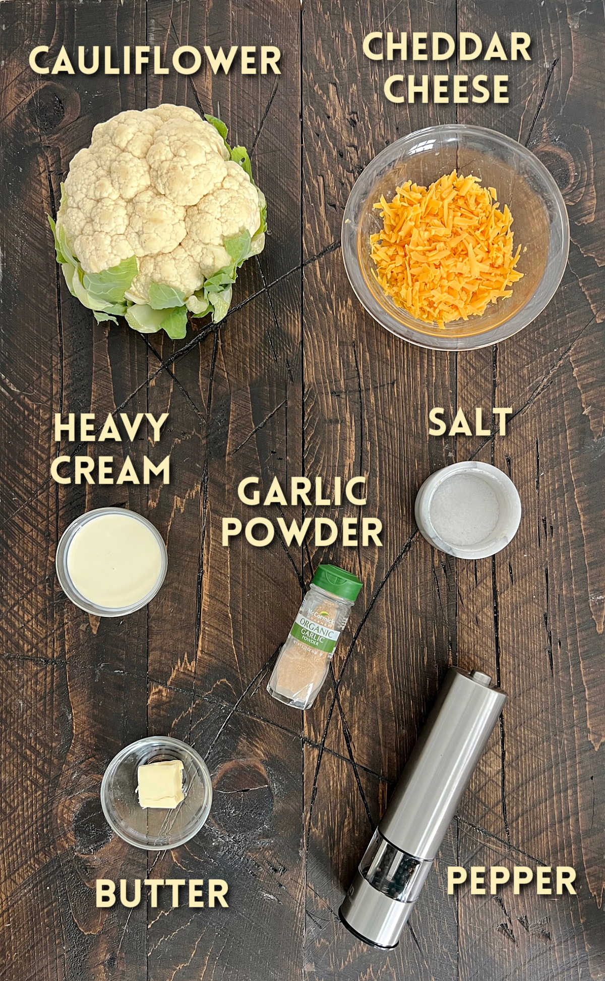 Ingredients for cauliflower mac and cheese on a wooden board.