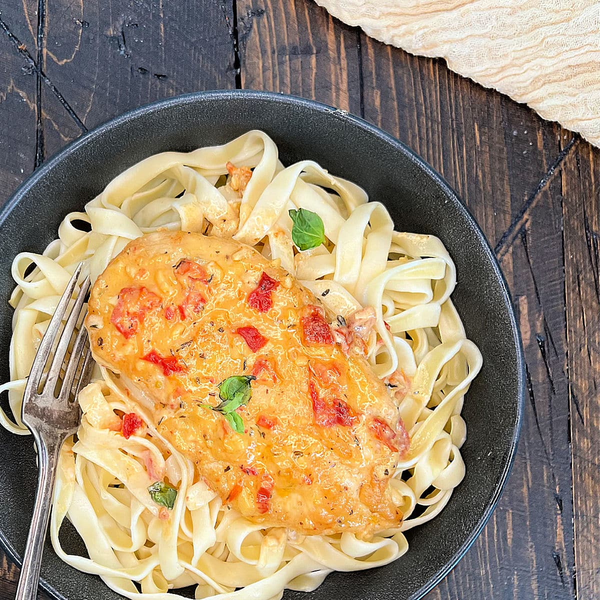 Marry me chicken in a bowl on a bed of fettucinni.