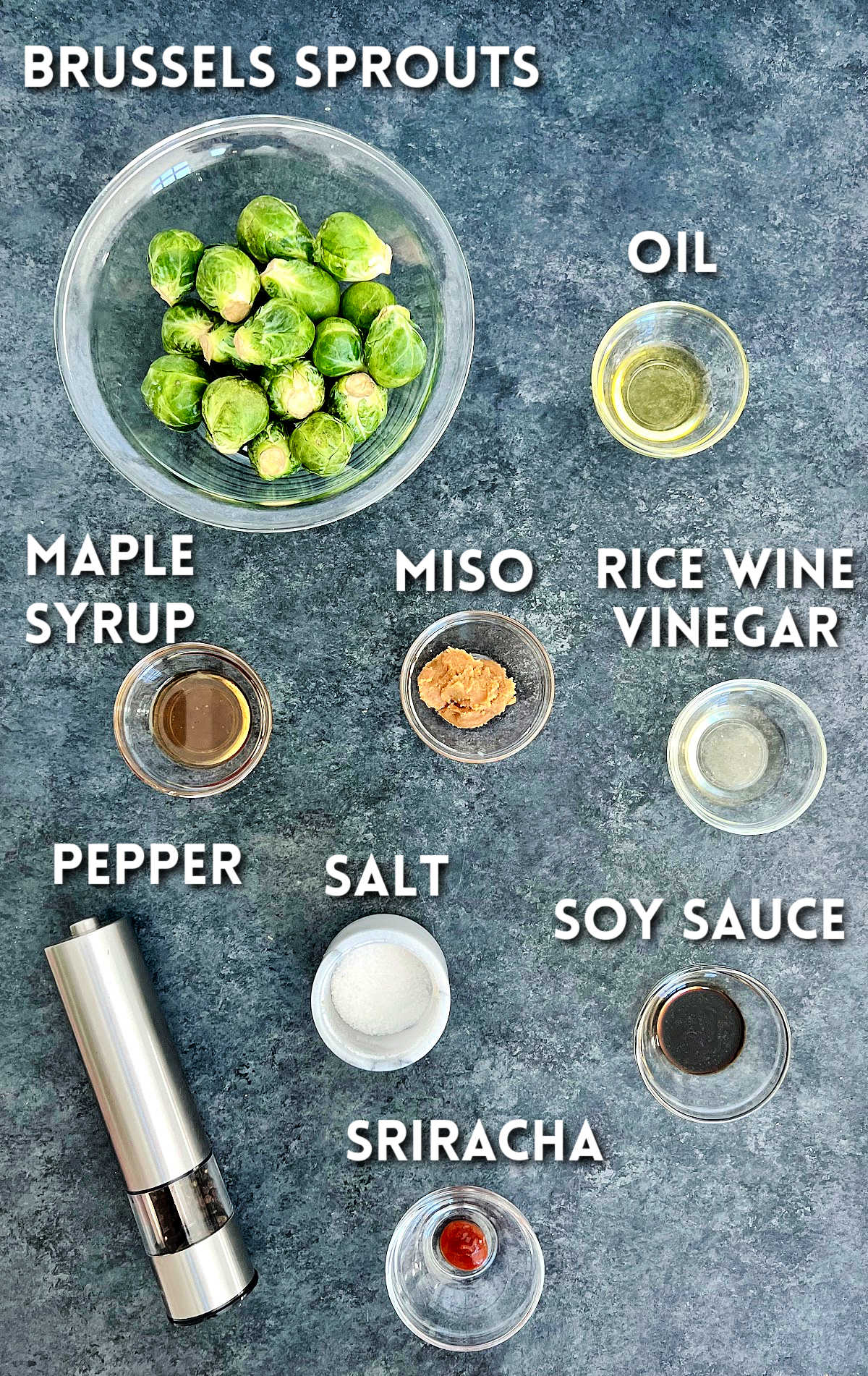 Ingredients for miso roasted brussels on a gray board.