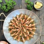 Overhead of shrimp oreganata arranged in a copper pan
