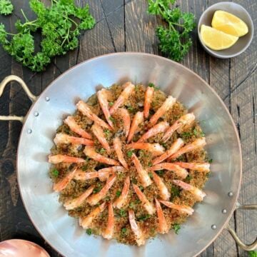 Overhead of shrimp oreganata arranged in a copper pan