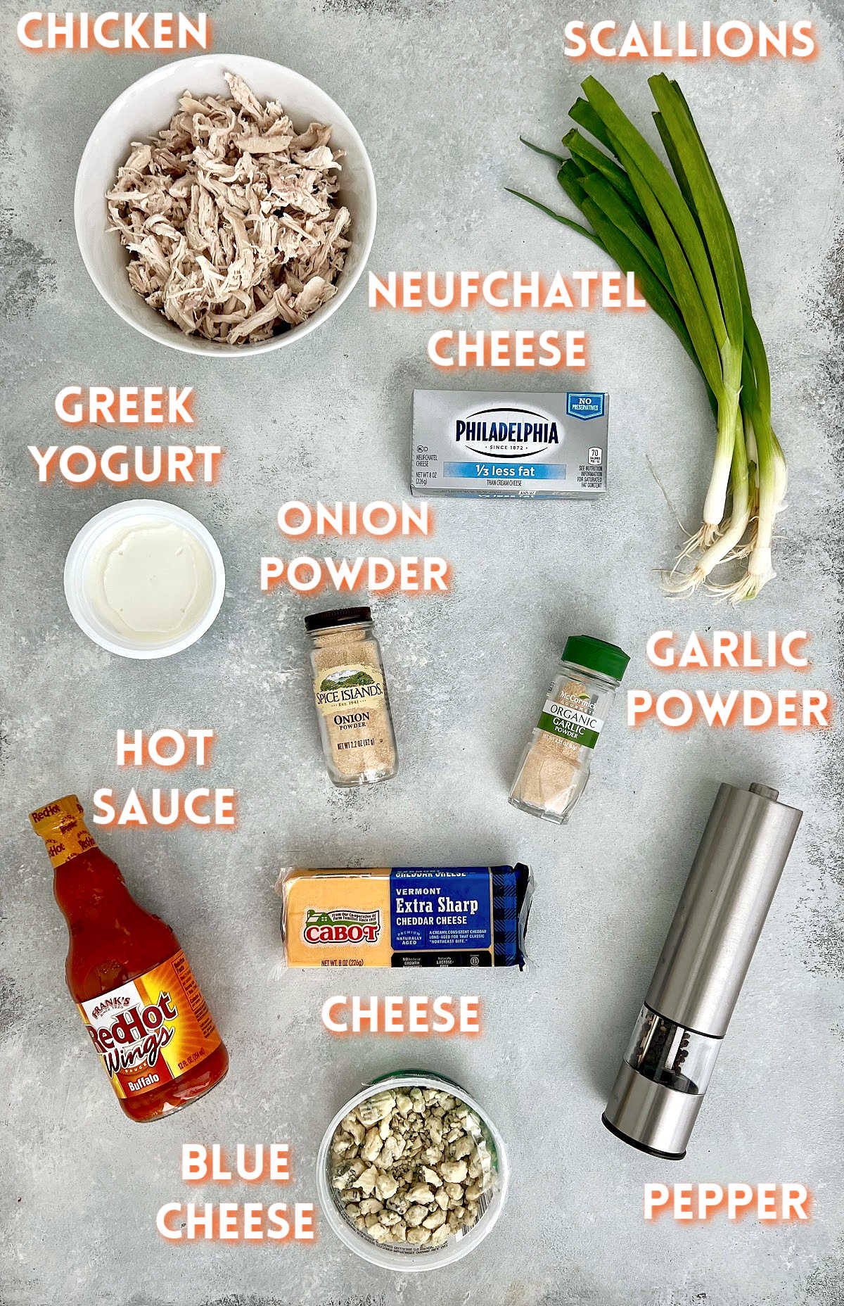 Ingredients for healthy buffalo chicken dip on a gray board.