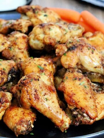 Pile of air fryer chicken wings on black plate