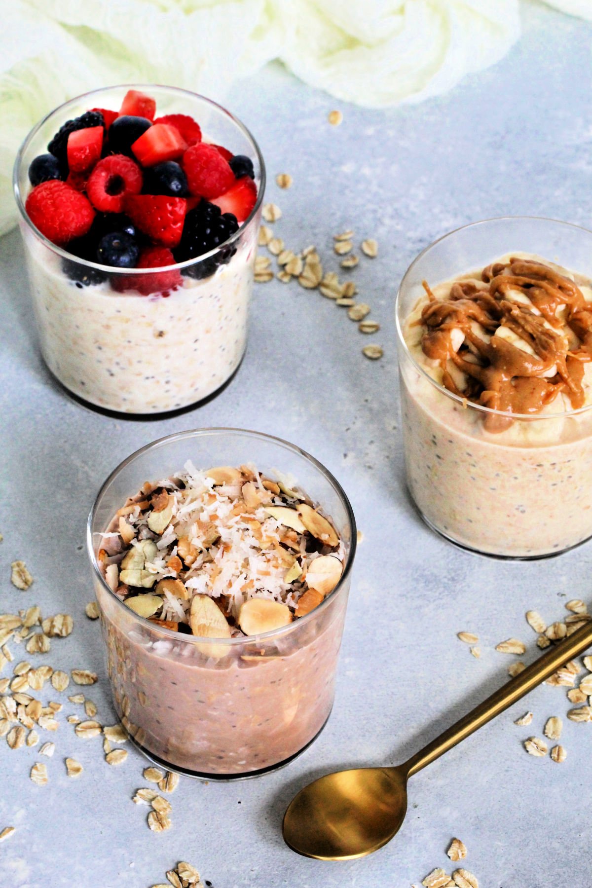 Varieties of protein overnight oats with a gold spoon.