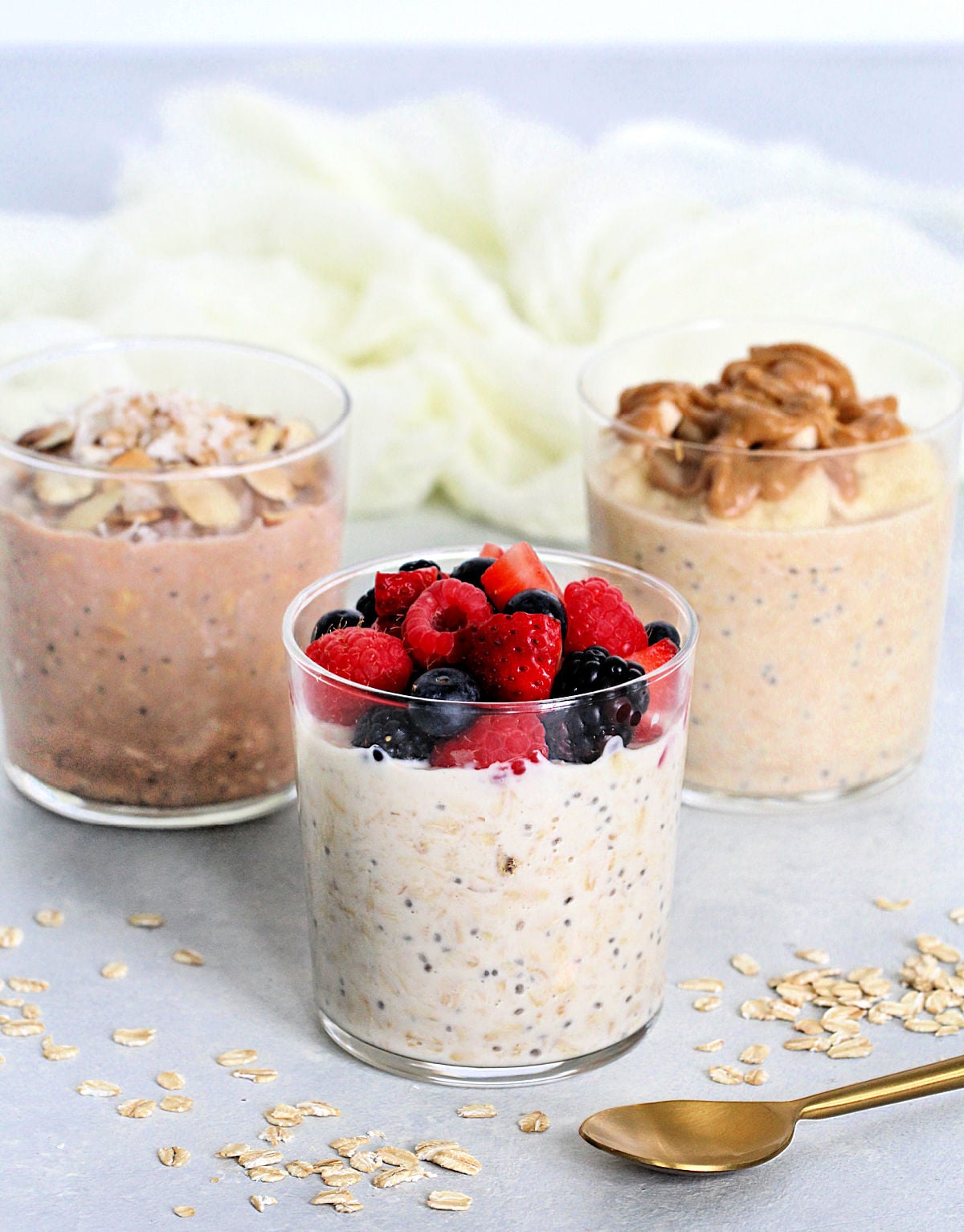 3 cups of protein overnight oats with different toppings.